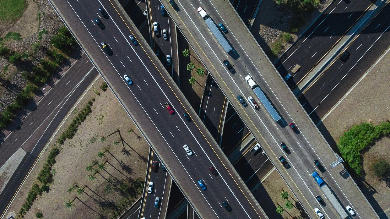 Luftaufnahme eines mehrstöckigen Autobahnkreuzes, auf dem sich Fahrspuren in mehreren Ebenen kreuzen und überlagern